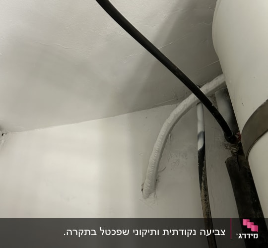צינורות שחורים ולבנים על קיר צבוע בלבן